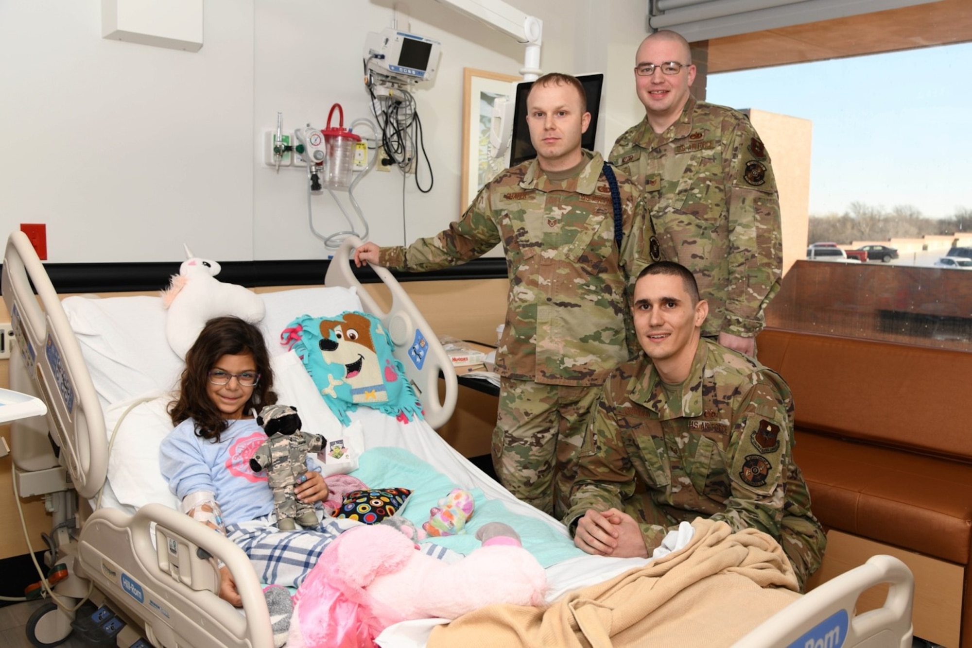 Staff Sgt. Joshua Shafer, Tech. Sgt. Kyle Nizzio and Tech Sgt. Joseph Gordon, instructors from the 373rd Training Squadron, Detachment 8, smile after delivering a military-dressed teddy bear to a child Dec. 10, 2019 at Wesley Children’s Hospital, in Wichita, Kan. The Airmen wanted to spread holiday cheer and deliver teddy bears during their second annual Teddy Bear Drop. (U.S. Air Force photo by Airman 1st Class Nilsa E. Garcia)