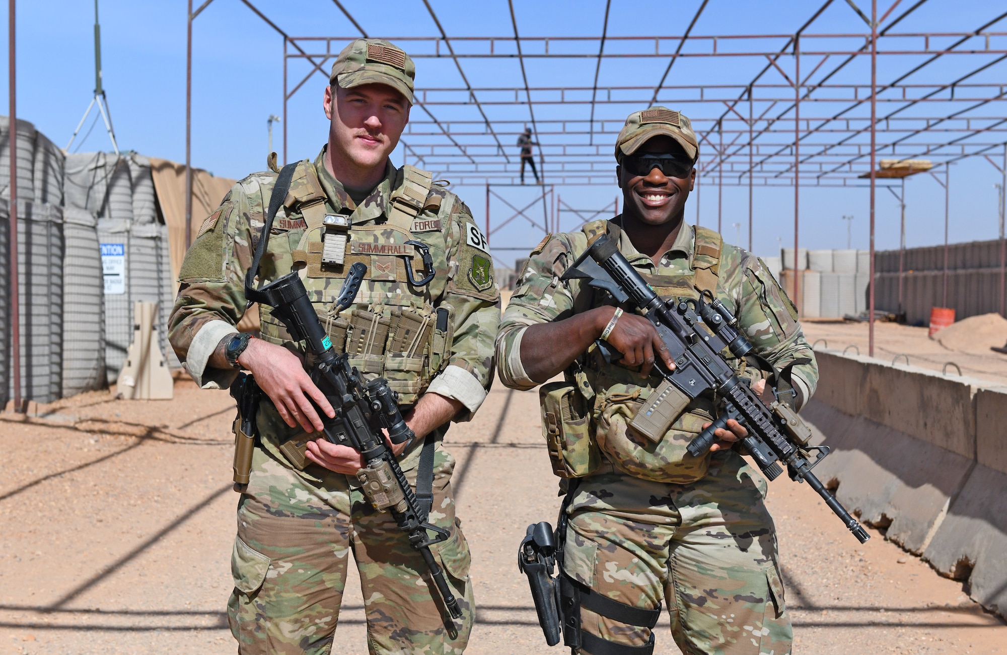 U.S. Air Force Senior Airmen Colton Summerall, left, and Jamuir Taylor, 409th Expeditionary Security Forces Squadron members, monitor contractors working on a new vehicle inspection area at Nigerien Air Base 201 in Agadez, Niger, Dec. 9, 2019. The 409th ESFS vigilantly defend the base and its assets through constant patrols, vehicle inspections and the vetting of all personnel working on the installation. (U.S. Air Force photo by Staff Sgt. Alex Fox Echols III)