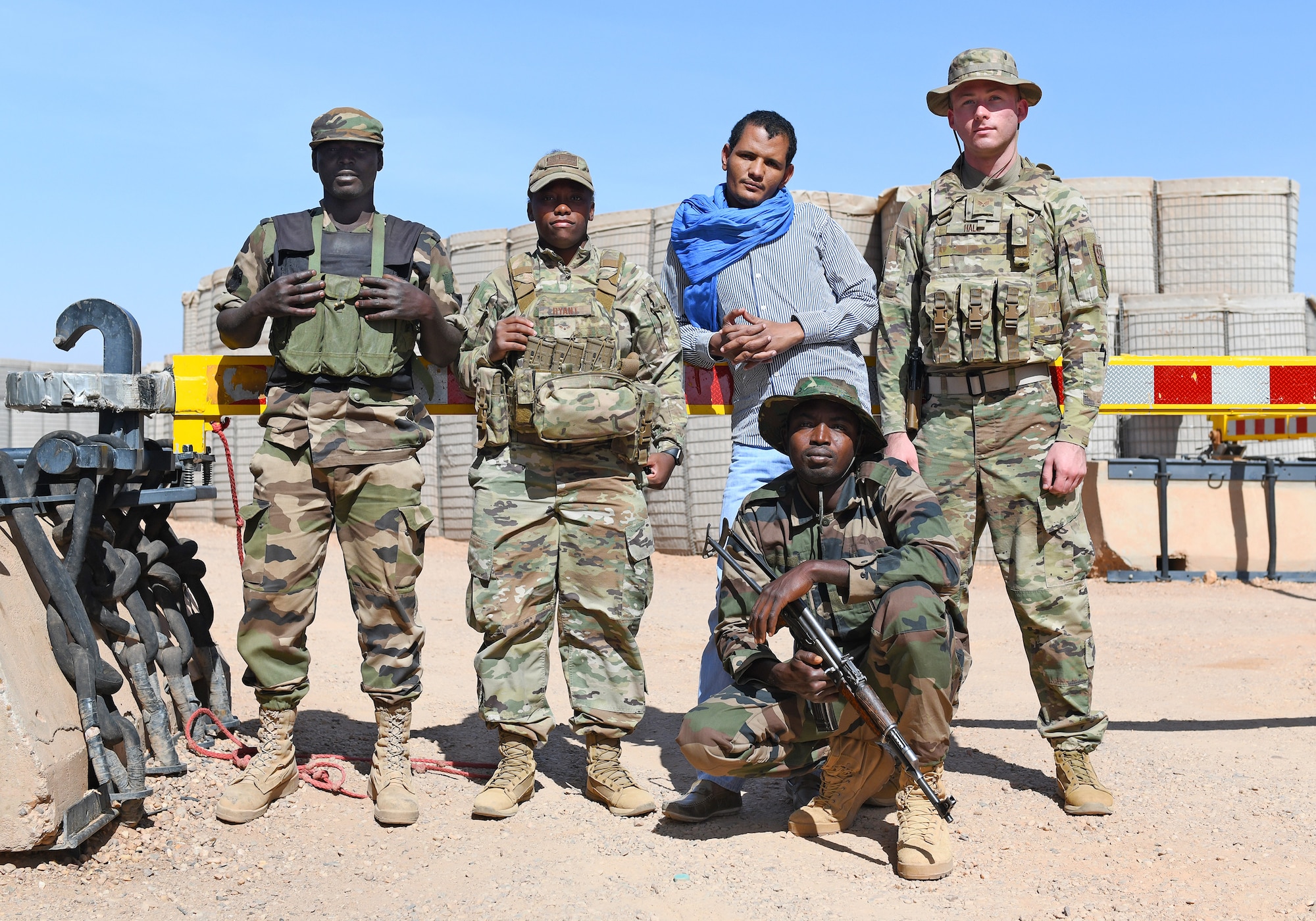 U.S. Airmen deployed to the 409th Expeditionary Security Forces Squadron, the Forces Armées Nigeriennes (Nigerien Armed Forces) members and their translator guard an entry control point at Nigerien Air Base 201 in Agadez, Niger, Dec. 9, 2019. Together, the FAN and the 409th Expeditionary Security Forces Squadron defend the base and its assets. (U.S. Air Force photo by Staff Sgt. Alex Fox Echols III)
