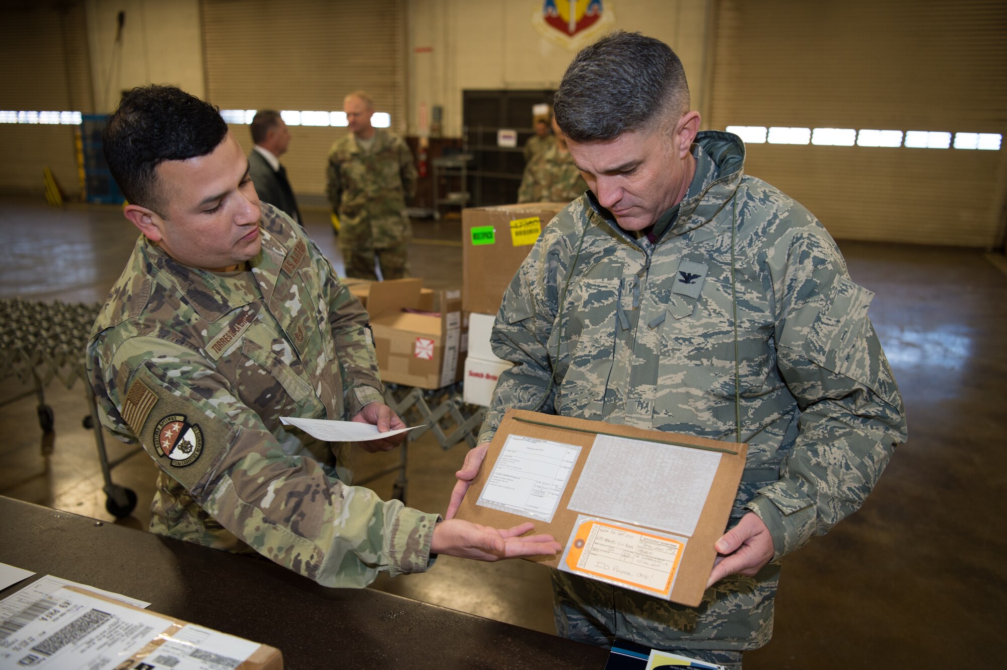 U.S. Air Force Tech Sgt. Juan Torres De La Cruz, 733rd Logistics Readiness Squadron inbound cargo noncommissioned officer in charge, explains the process an inbound package goes through to Col. Clinton Ross, 633rd Air Base Wing commander, at Joint Base Langley-Eustis, Virginia, Dec. 6, 2019. The package started at inbound cargo and followed the process through storage at Mobility Readiness Spares Package, ending at the customer. (U.S. Air Force photo by Senior Airman Tristan Biese)