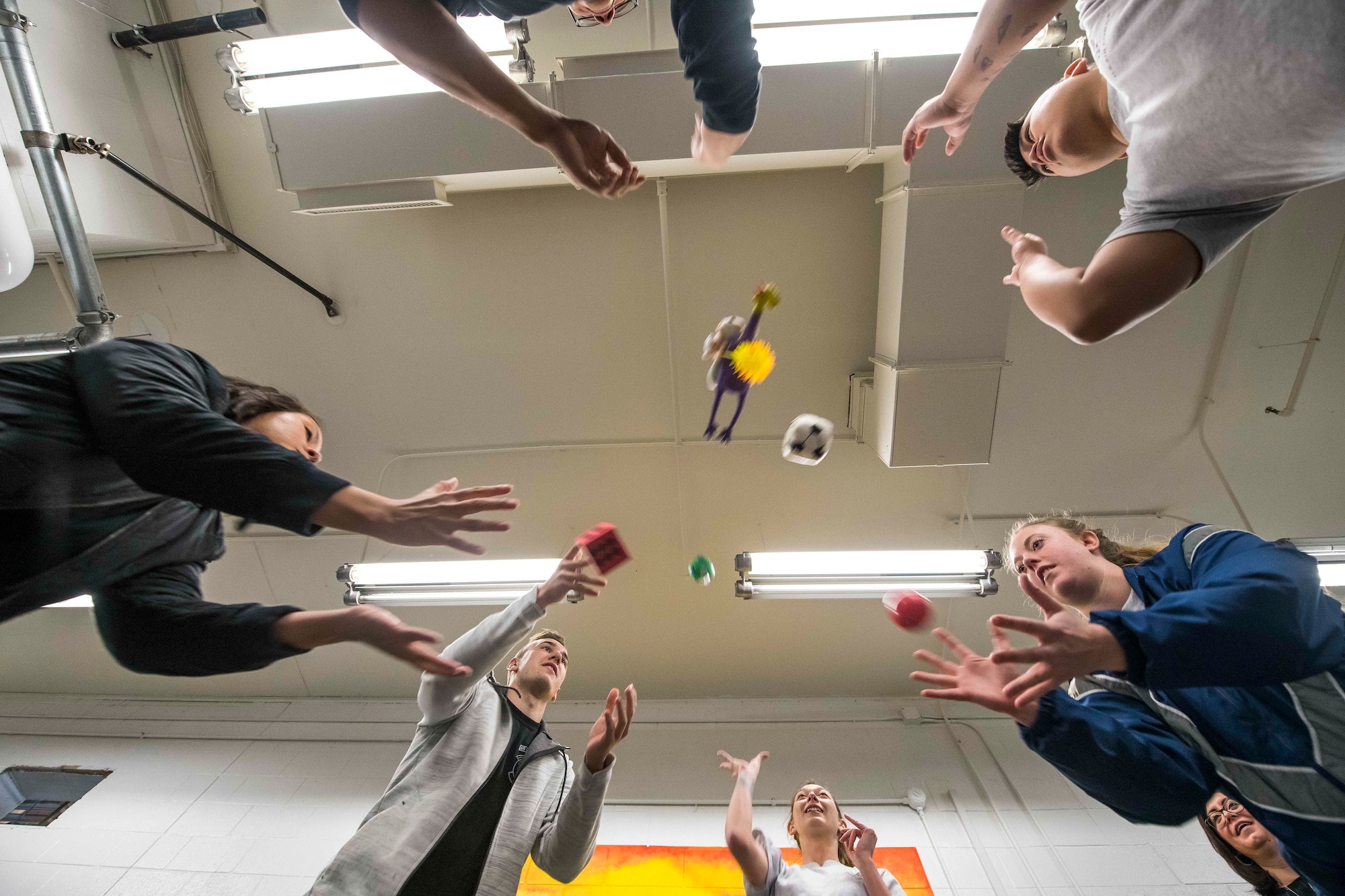 Members of the 27th Special Operations Logistics Readiness Squadron throw an assortment of items for a teambuilding exercise during the Individuals Caring Attitude Resiliency and Empowerment event at Cannon Air Force Base, N.M., Dec. 6, 2019. During the meeting, members were able to share their stories with others in a safe space. (U.S. Air Force photo by Senior Airman Vernon R. Walter III)
