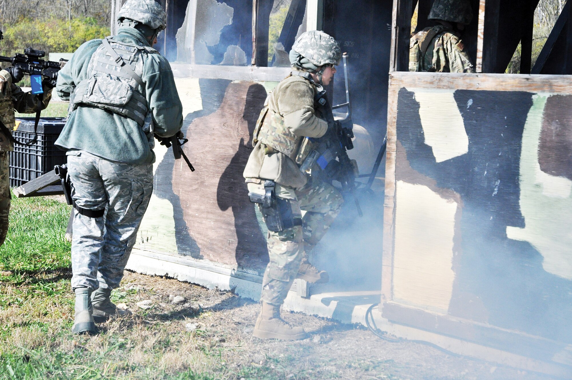 Master Sgt. Jesse Canan, flight chief, and Staff Sgt. Brittany Robertson, fire team member, both with the 178th Security Forces Squadron from Springfield Air National Guard Base, Ohio, rush into a smoke-filled structure during building clearing and sweeping training at the Warfighter Training Center on Wright-Patterson Air Force Base, Ohio, Nov. 2, 2019.