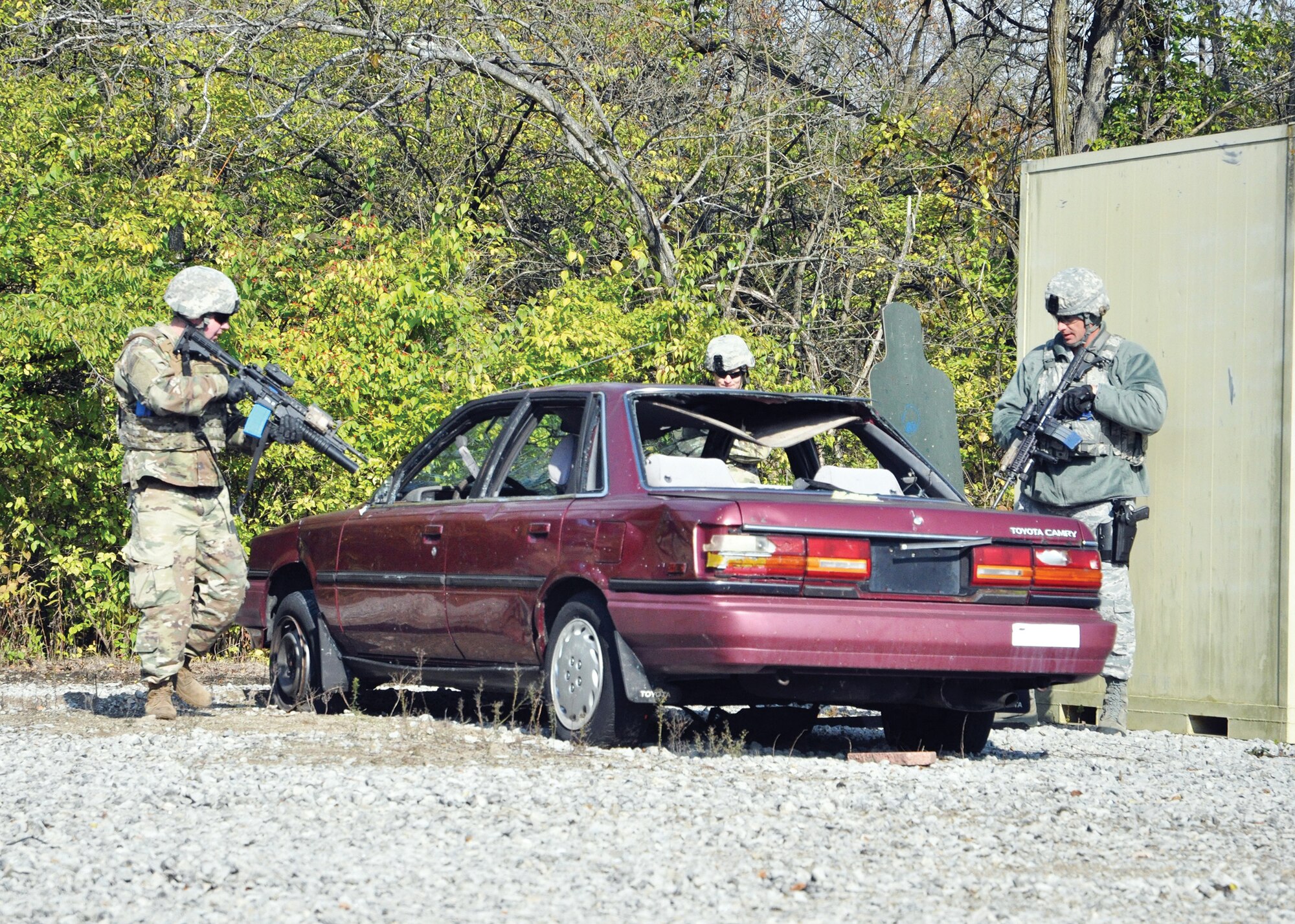 Staff Sgt. Justin Daley, left, 445th Security Forces Squadron fire team member, and Master Sgt. Jesse Canan, right, 178th SFS flight Chief, clear a vehicle as part of shoot, move, communicate training at the Warfighter Training Center on Wright-Patterson Air Force Base, Ohio, Nov. 2, 2019, while Tech. Sgt. Jacob McCorkle, 445th SFS fire team leader, observes to provide feedback to the team.