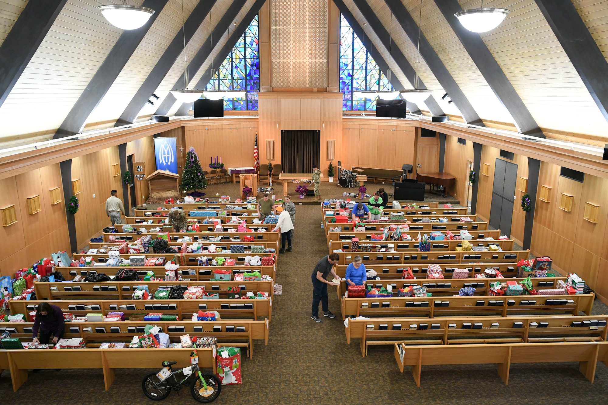Pews lined up in the base chapel are filled with wrapped gifts as pictured from the balcony at the back of the chapel.
