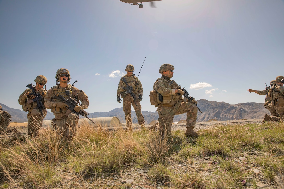 Soldiers move out in terrain.