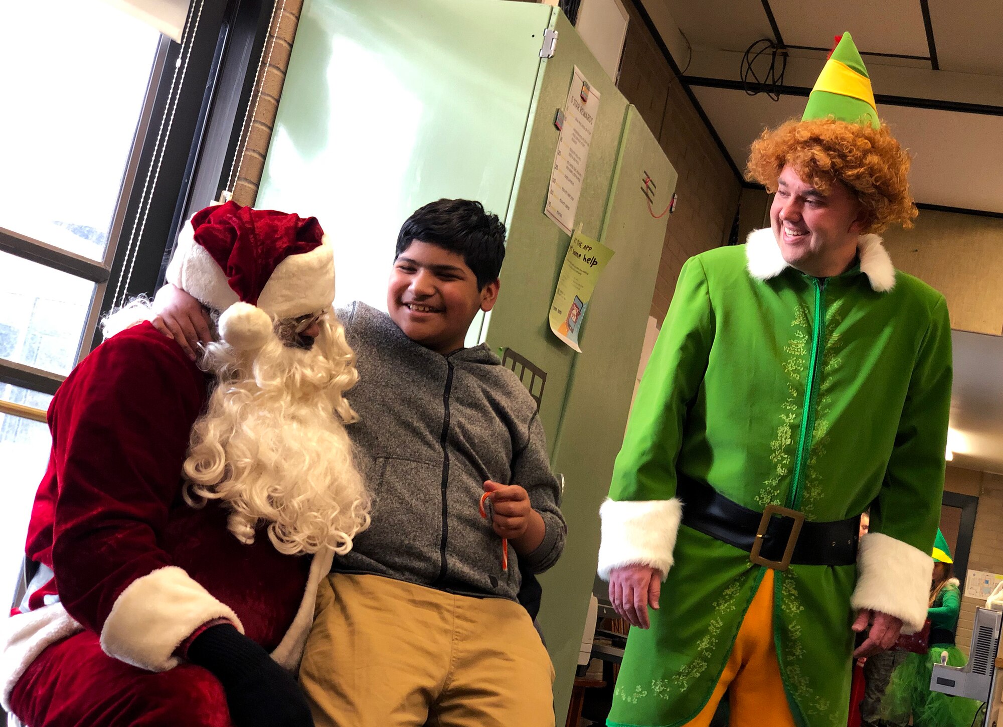 Eduardo talks to Santa Claus and Buddy the Elf during a Christmas party for students with special needs at Ogden’s Mound Fort Junior High Dec. 11