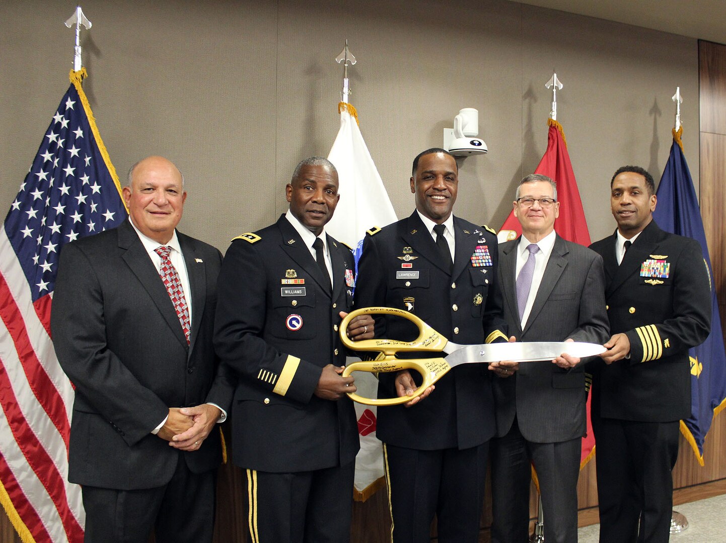 The ceremonial scissors used during the ribbon cutting for Building 45 were signed by (pictured left to right) Yogi Mangual, former Defense Logistics Agency Troop Support commander, Army Lt. Gen. Darrell Williams, director of the Defense Logistics Agency, Army Brig. Gen. Gavin Lawrence, commander of Defense Logistics Agency Troop Support; Richard Ellis, deputy commander of Defense Logistics Agency Troop Support; and Navy Capt. Preston Gill, commanding officer of Naval Support Activity Mechanicsburg. The ceremony was held on Dec. 10, 2019 at the Defense Logistics Agency Troop Support headquarters in Philadelphia. (Photo by Nancy Benecki)