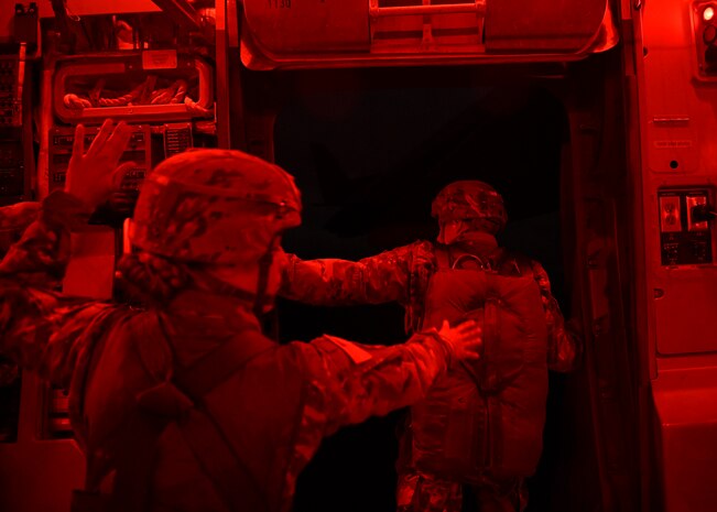 Capt. Monica Notzon, CO Commander, assigned to the 118th MP CO (ABN), from Fort Bragg, N.C., communicates with a jumpmaster and loadmaster over the Nevada Testing and Training Range, Nevada., December 7, 2019.