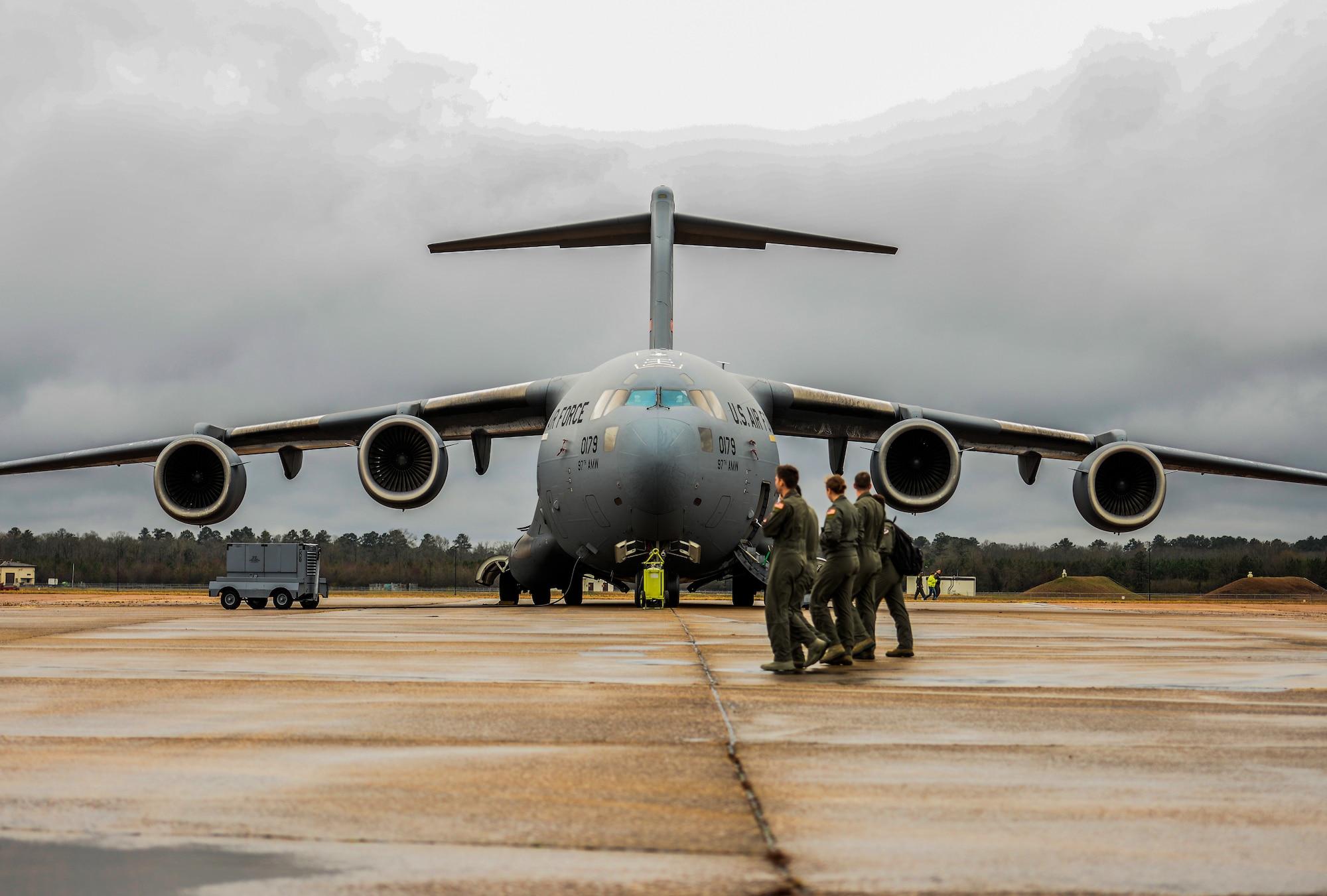 Four Airmen walk in front of a C-17 Globemaster III Dec. 10, 2019, at Columbus Air Force Base, Miss. The C-17 measures 174 feet long (53 meters) with a wingspan of 169 feet, 10 inches (51.75 meters). (U.S. Air Force photo by Airman Davis Donaldson)