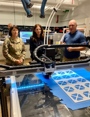 From left to right, Brigadier Gen. Patrice Melancon, Tyndall Program Management Office executive director, Dr. Julia Nesheiwat, Florida Chief Resilience Officer and Dr. Jeff Owens, Air Force Civil Engineer research scientist, observe a 3D printer producing materials for testing during a visit to the AFCEC research lab.