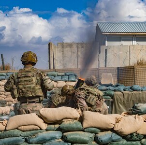 Soldiers fire mortar.