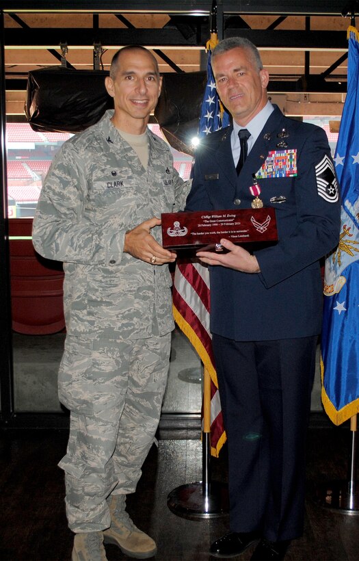 Col. Lance Clark, AFIMSC Detachment 9 commander, presents Chief Master Sgt. William Ewing with a gift during Ewing’s retirement ceremony.
