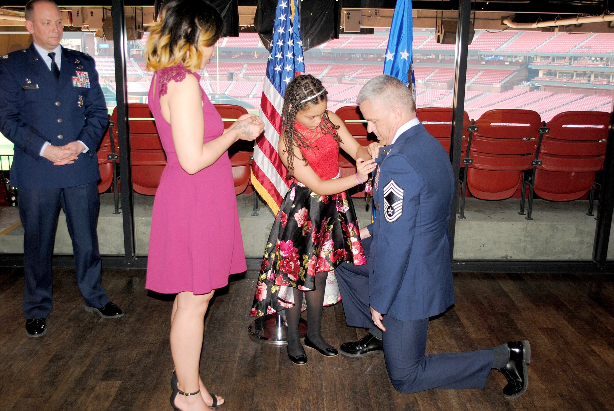 Chief Master Sgt. William Ewing’s daughters place a retirement on his lapel during his retirement ceremony.