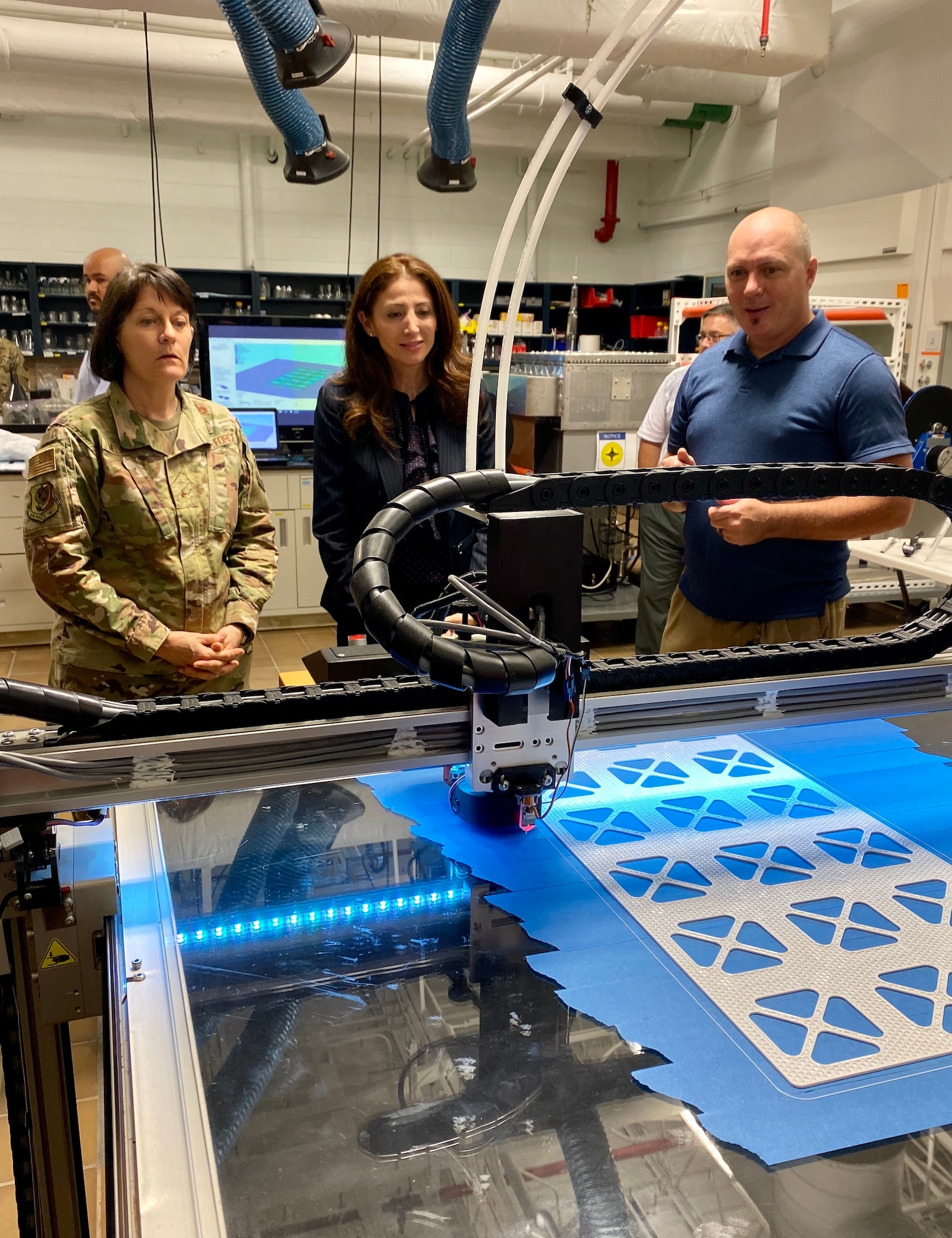 From left to right, Brigadier Gen. Patrice Melancon, Tyndall Program Management Office executive director, Dr. Julia Nesheiwat, Florida Chief Resilience Officer and Dr. Jeff Owens, Air Force Civil Engineer research scientist, observe a 3D printer producing materials for testing during a visit to the AFCEC research lab.