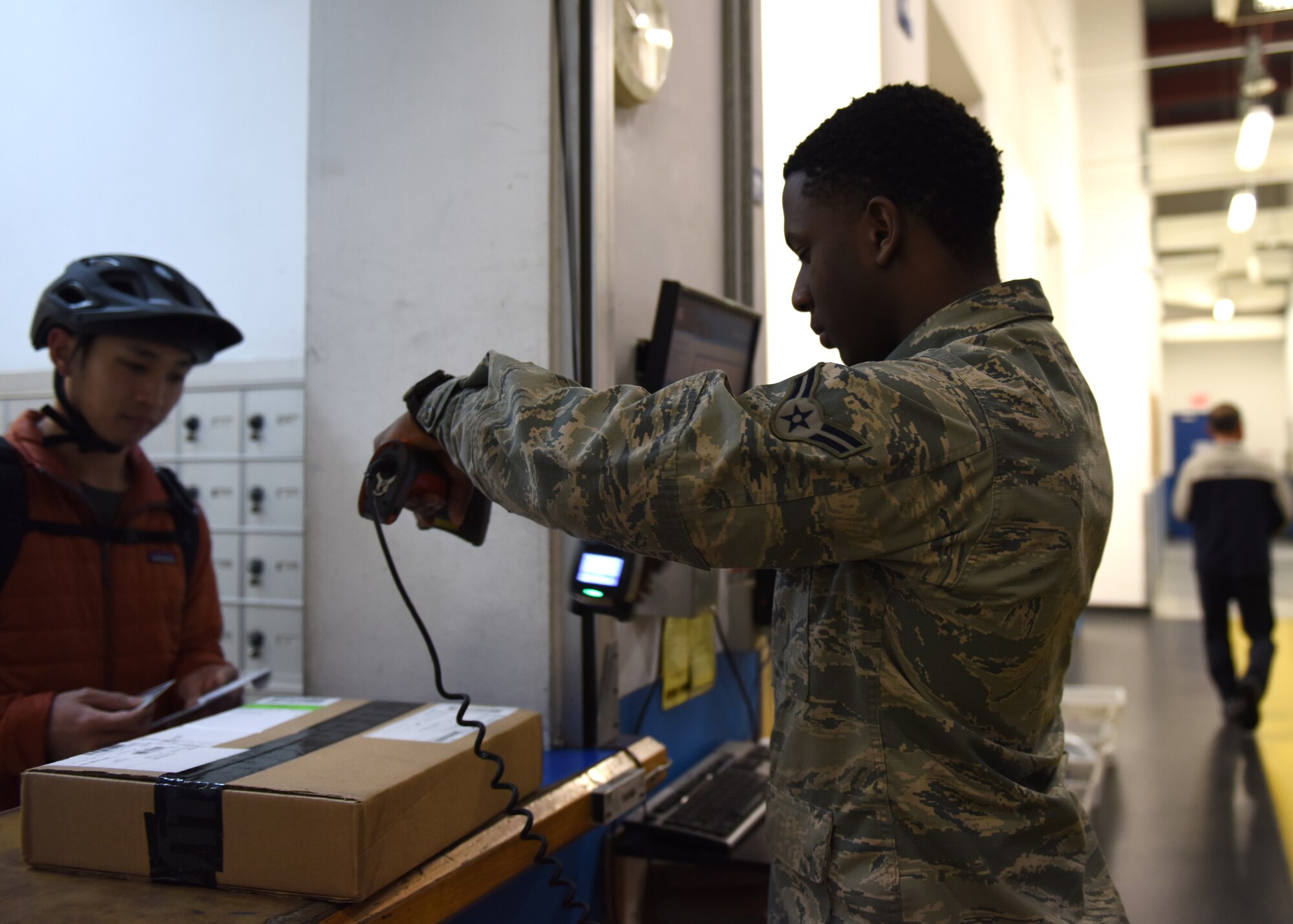 Airman 1st Class Tyrique Thompson, 51st Force Support Squadron postal clerk scans out a customer’s package at the post office on Osan Air Base, Republic of Korea, Dec. 11, 2019. To track that a customer has picked up their package, their ID card is scanned as well as the shipping label on the package. (U.S. Air Force photo by Senior Airman Denise Jenson)