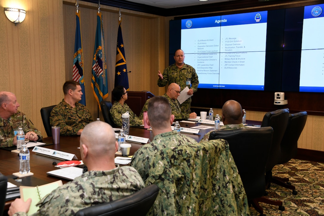 Navy Cmdr. Ryan Baum delivers an overview brief on DLA Disposition Services operations and the support provided from the team.