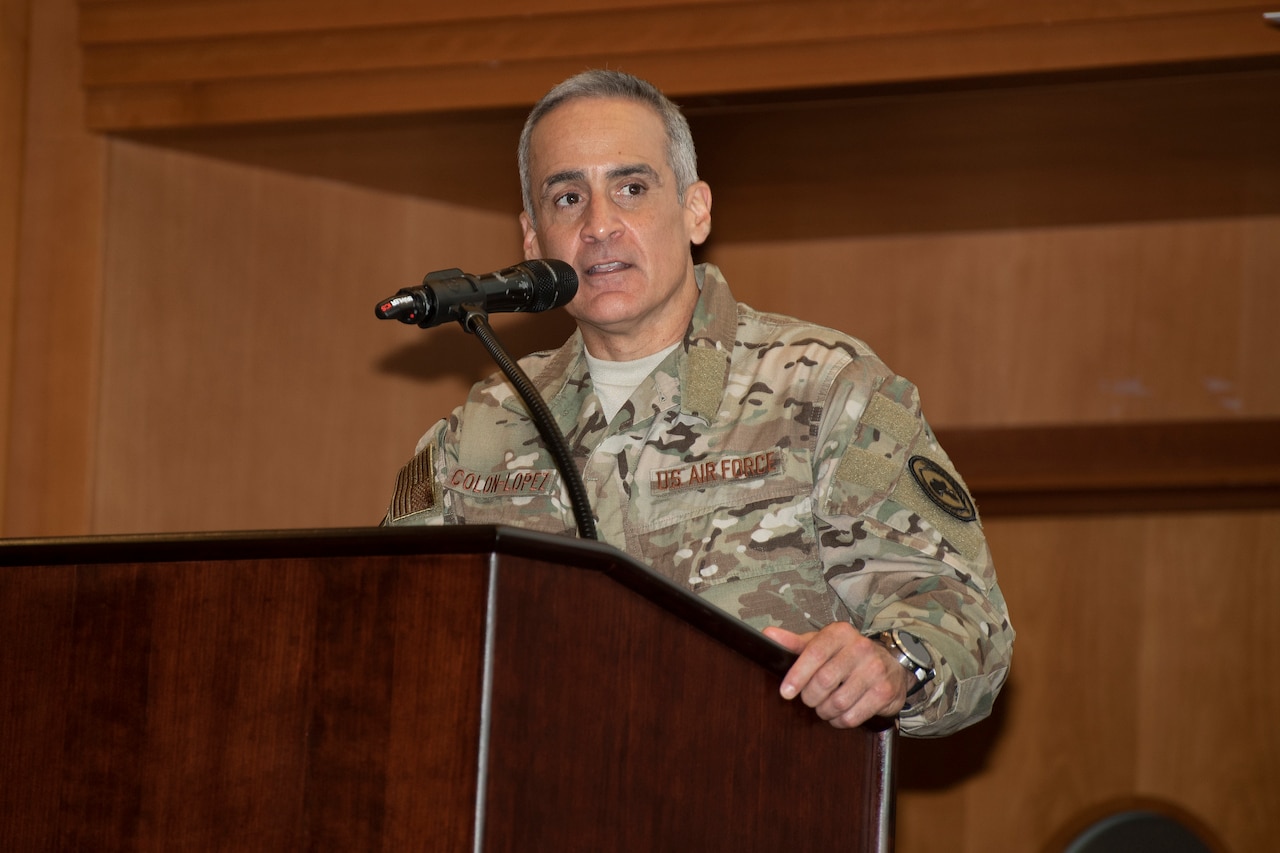 A military leader speaks from behind a podium.