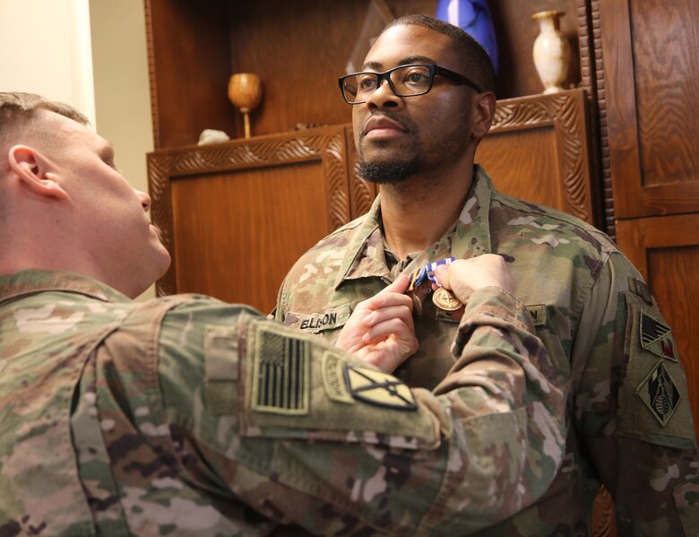 Medals are strategically placed on USACE Afghanistan District redeploying team member Derland Ellison by Lt. Col. Dan Hayden, Deputy Commanding Officer Afghanistan District.