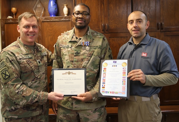 Lt. Col. Dan Hayden, Afghanistan District Deputy Commander presents the Global War on Terrorism Medal to Derland Ellison, who redeployed from the Afghanistan District, while Adam Walker, Deputy Construction Chief, Bagram Resident Office displays the NATO medal certificate Ellison was awarded.