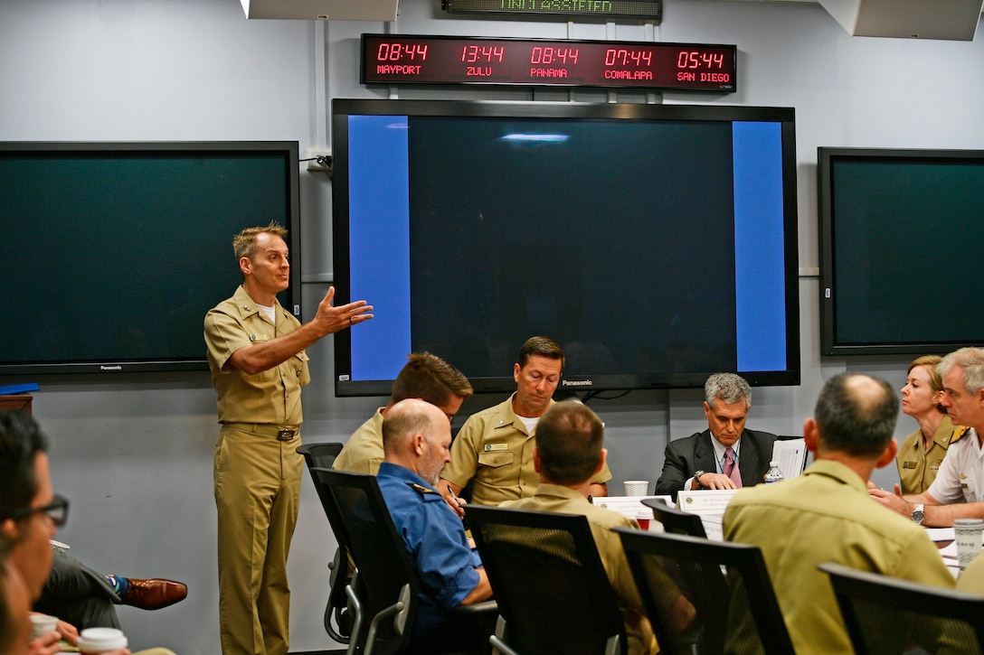 A Navy admiral talks to a group of military personnel.
