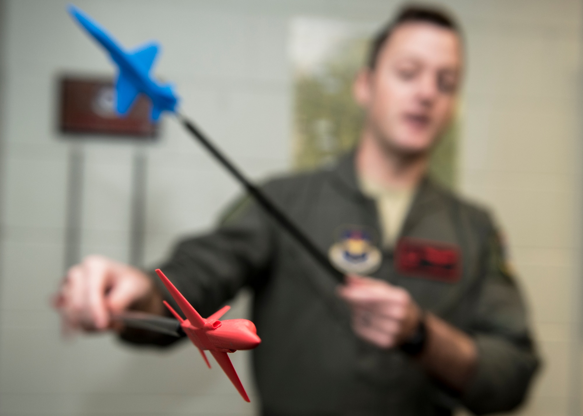 An Euro-NATO Joint Jet Pilot Training Program student pilot uses red and blue planes to show aircraft formation types at Sheppard Air Force Base, Texas, Dec. 10, 2019. The red plane represents the "bandit plane" which basically means the "bad" plane, while the blue plane represents the ENJJPT pilot. Using the red and blue planes, the instructor can show different scenarios and where the ENJJPT pilots should be in each situation. (U.S. Air Force photo by Senior Airman Pedro Tenorio)