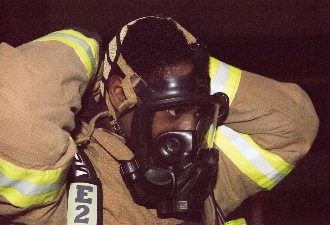 An 86th Civil Engineer Squadron firefighter dons fire protective gear during Exercise Operation Varsity 19-04 at Ramstein Air Base, Germany, Dec. 10, 2019. The scenario began with an aerial attack, resulting in the simulated fire. The scenario was part of Exercise Operation Varsity 19-04, which tested units across the 86th Airlift Wing in their response to various contingency scenarios.