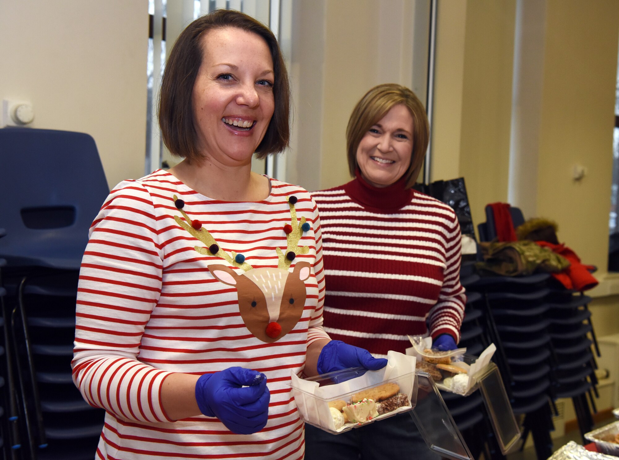 Team Mildenhall volunteers pose for a photo while packaging holiday cookies during the annual Holiday Cookie Drive at RAF Mildenhall, England, Dec. 12, 2019. The cookie drive takes place during the first part of December to provide base dorm residents a comforting taste of home. (U.S. Air Force photo by Senior Airman Brandon Esau)