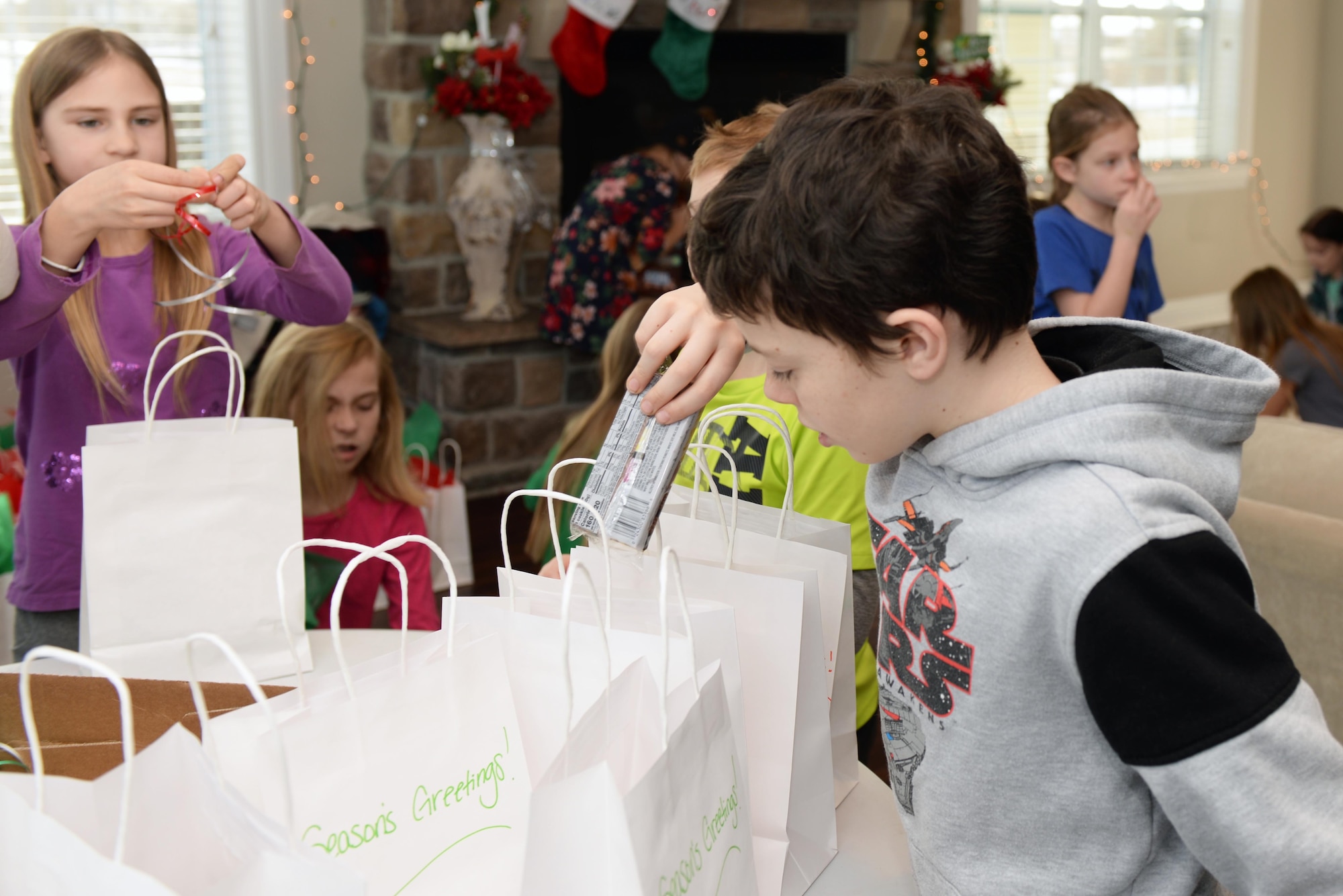 Children and teachers from St. Paul’s School in Rapid City, S.D., package cookies for the Cookie Drive at Ellsworth Air Force Base, Dec. 9, 2019. The students created handmade, personalized holiday cards and put them in every bag of cookies prior to the cookies being delivered to more than 700 dormitory Airmen assigned to Ellsworth. (U.S. Air Force photo by Airman Quentin K. Marx)