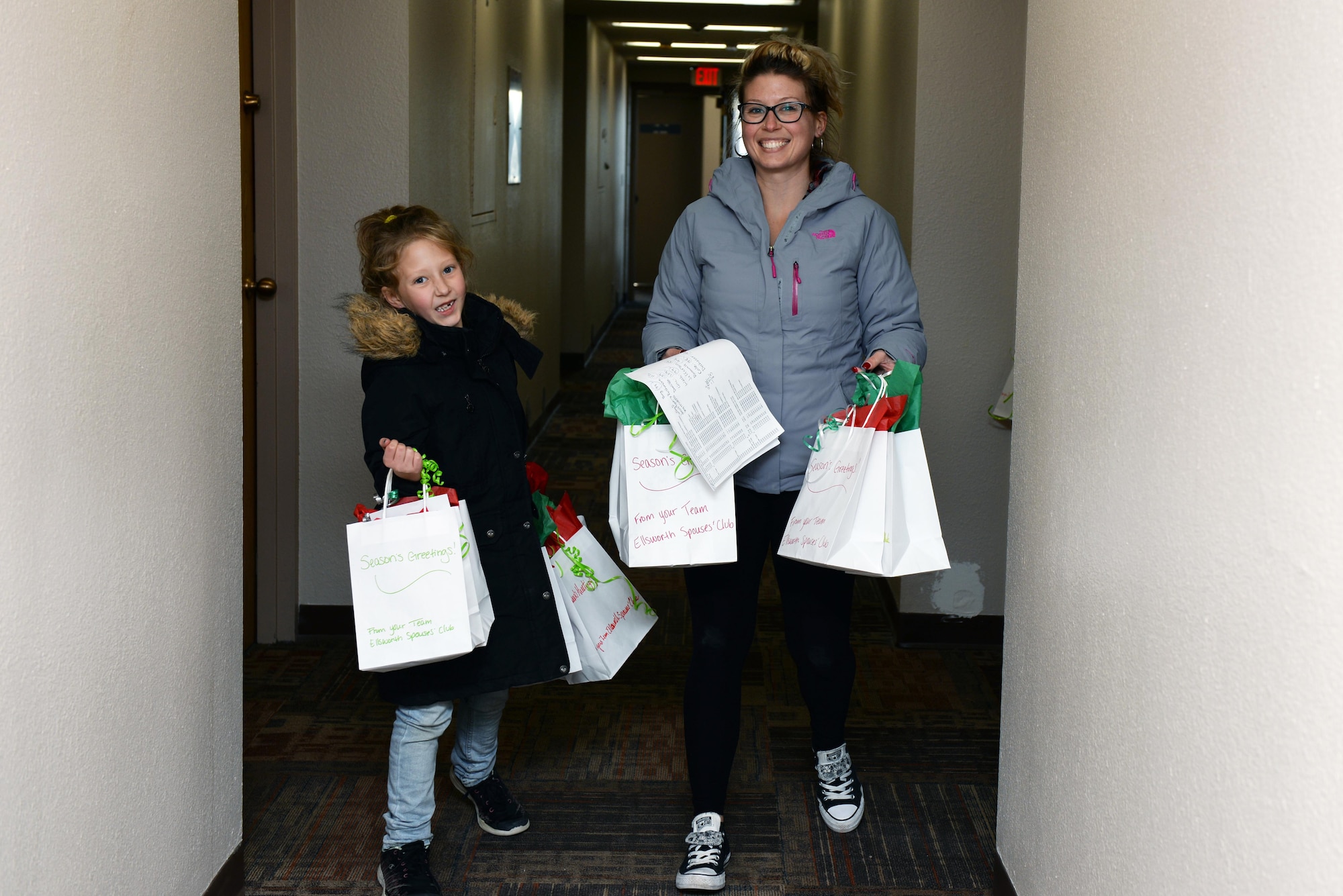 Heather Ryan, the Ellsworth Spouse’s Club Fundraising chairperson, and a student from the St. Paul’s School deliver cookies to Airmen residing in the dormitories at Ellsworth Air Force Base, S.D., Dec. 9, 2019. More than 12,000 cookies were packaged and delivered to more than 700 dorm Airmen, spreading holiday cheer to those away from their families this year. (U.S. Air Force photo by Airman Quentin K. Marx)