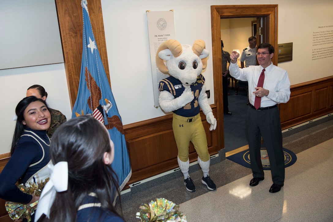 Defense Secretary Dr. Mark T. Esper greets cheerleaders at the Pentagon.