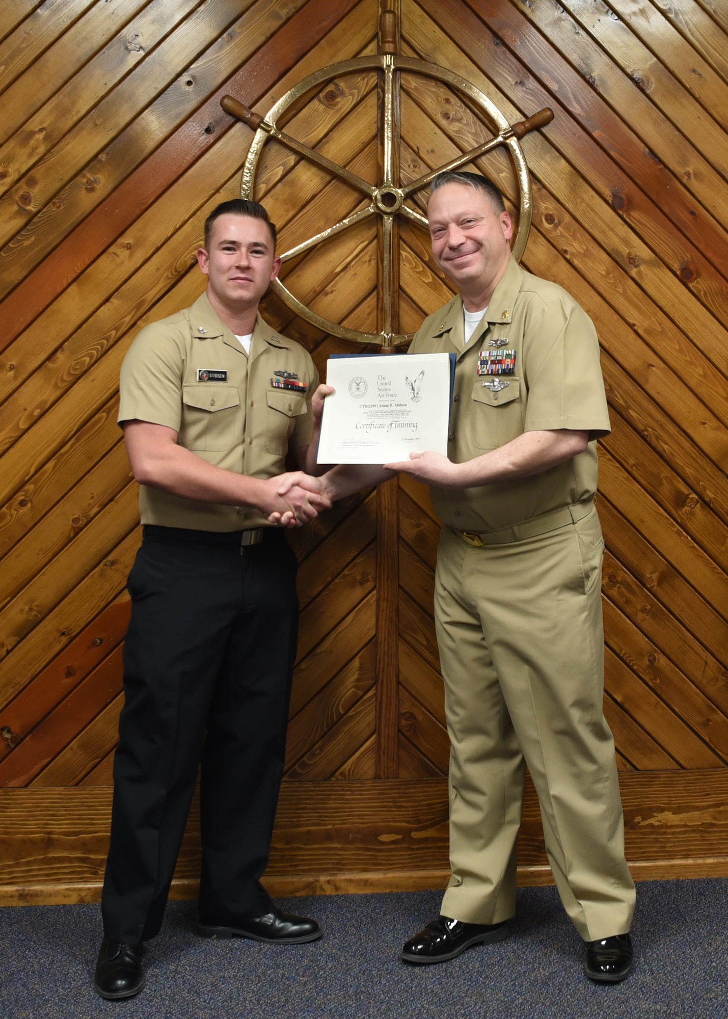 U.S. Navy Petty Officer 2nd Class Adam Stidsen, 316th Training Squadron cryptologic technician, receives a Letter of Commendation for being the Top Graduate of the Navy Analysis and Reporting course from Master Chief Petty Officer Joseph Rynolds, Navy senior enlisted leader, at the Center for Information Warfare Training Detachment on Goodfellow Air Force Base, Texas, Dec. 12, 2019. Stidsen completed the 560 hour course with the academic average of 98.5%. (U.S. Air Force photo by Airman 1st Class Abbey Rieves)