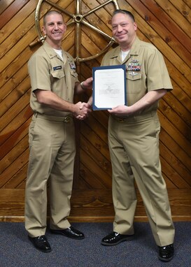 U.S. Navy Chief Petty Officer Nicholas Messia, 316th Training Squadron cryptologic technician, receives a Letter of Commendation for being the Top Graduate of the Navy Analysis and Reporting course from Master Chief Petty Officer Joseph Rynolds, Navy senior enlisted leader, at the Center for Information Warfare Training Detachment on Goodfellow Air Force Base, Texas, Dec. 12, 2019.  Messia completed the 560 hour course with the academic average of 97.2%. (U.S. Air Force photo by Airman 1st Class Abbey Rieves)