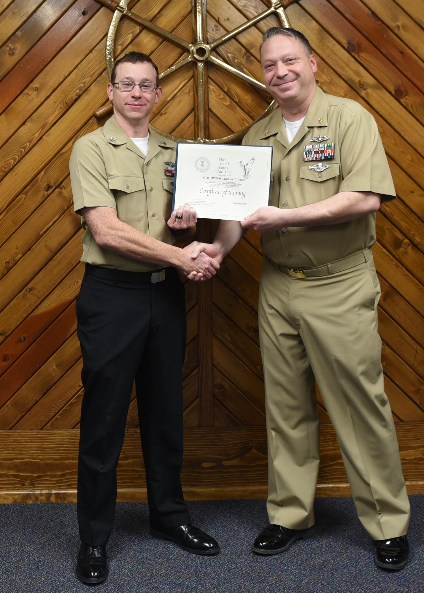 U.S. Navy Petty Officer 2nd Class, Andrew Burns, 316th Training Squadron cryptologic technician, receives a Letter of Appreciation from Master Chief Petty Officer Joseph Rynolds, Navy senior enlisted leader, during the Navy Analysis and Reporting course graduation ceremony at the Center for Information Warfare Training Detachment on Goodfellow Air Force Base, Texas, Dec. 12, 2019. Burns’ volunteerism in the community demonstrated his understanding of the Navy’s core value, commitment. (U.S. Air Force photo by Airman 1st Class Abbey Rieves)
