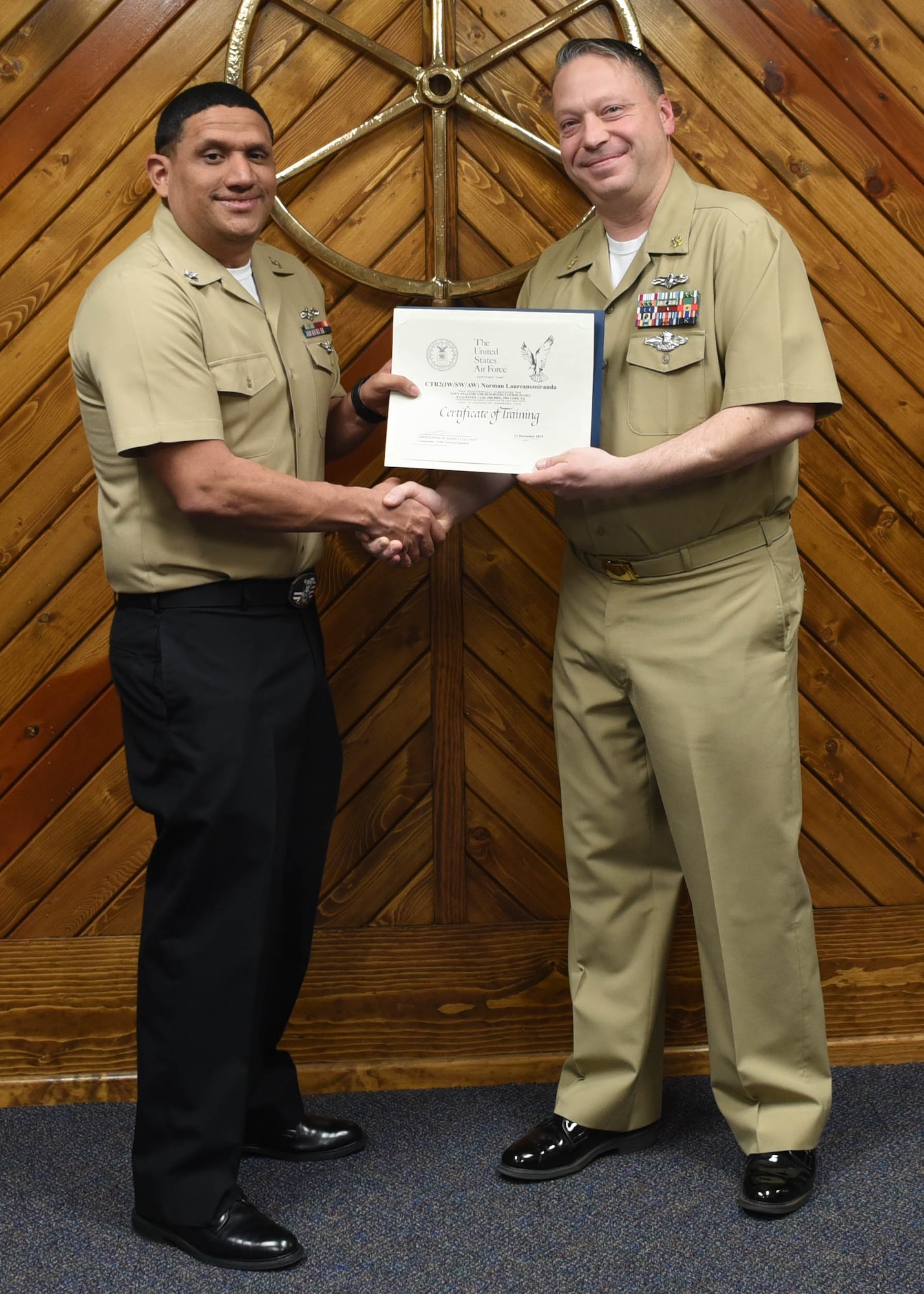 U.S. Navy Petty Officer 2nd Class Norman Laureano Miranda, 316th Training Squadron cryptologic technician, receives a Letter of Appreciation from Master Chief Petty Officer Joseph Rynolds, Navy senior enlisted leader, during the Navy Analysis and Reporting course graduation ceremony at the Center for Information Warfare Training Detachment on Goodfellow Air Force Base, Texas, Dec. 12, 2019.  Laureano Miranda received the award for volunteering 27 hours, which positively reflected a commitment to public service, community involvement and exemplified the highest standard of personal excellence. (U.S. Air Force photo by Airman 1st Class Abbey Rieves)