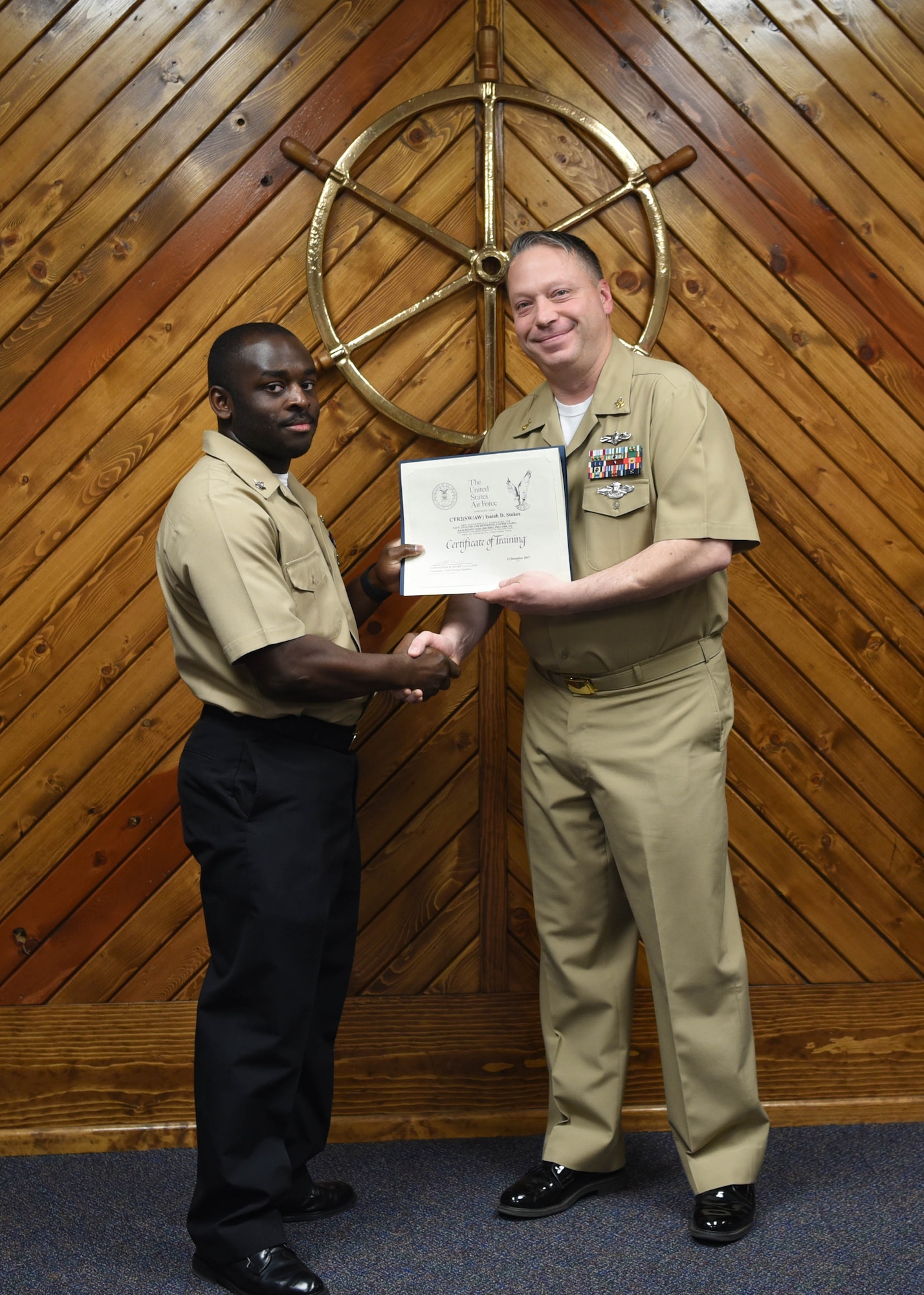 U.S. Navy Petty Officer 3rd Class Isaiah Stokes, 316th Training Squadron cryptologic technician, receives a Letter of Appreciation from Master Chief Petty Officer Joseph Rynolds, Navy senior enlisted leader, during the Navy Analysis and Reporting course graduation ceremony at the Center for Information Warfare Training Detachment on Goodfellow Air Force Base, Texas, Dec. 12, 2019. Stokes’ volunteerism in the community demonstrated his understanding of the Navy’s core value, commitment. (U.S. Air Force photo by Airman 1st Class Abbey Rieves)
