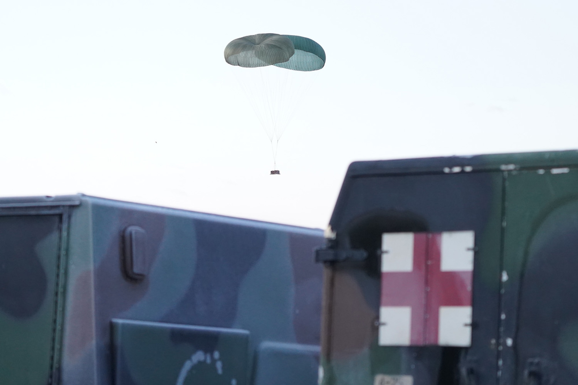 A pallet of heavy equipment Descends to the ground before paratroopers assigned to the 4th Infantry Brigade Combat Team (Airborne), 25th Infantry Division, U.S. Army Alaska, conduct a parachute jump on Malemute drop zone at Joint Base Elmendorf-Richardson, Alaska, Dec. 11, 2019. The Soldiers are part of the Army’s only Pacific airborne brigade with the ability to rapidly deploy worldwide, and are trained to conduct military operations in austere conditions.