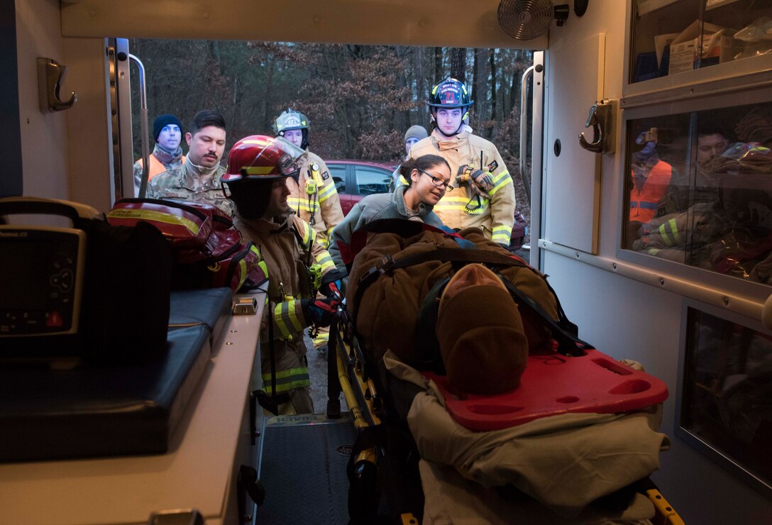 86th Medical Group emergency response technicians and 86th Civil Engineer Squadron firefighters load a simulated car crash victim into an ambulance during Exercise Operation Varsity 19-04 at Ramstein Air Base, Germany, Dec. 12, 2019. The scenario tested the 86th MDG, 86th CES, and 86th Security Forces Squadron on their ability to respond to a major accident. The scenario was part of Exercise Operation Varsity 19-04, which tested responses at Ramstein; Lajes Air Base, Portugal; Moron Air Base, Spain; and Chievres Air Base, Belgium.