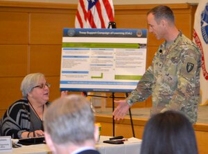 Army Col. Kennon Gilliam, strategic wargaming director for the Army Center for Strategic Leadership, right, discusses the “Game of 23” with DLA Troop Support Product Test Center Analytic lead scientist Jamie Hieber during an event Dec. 5, 2019, in Philadelphia.