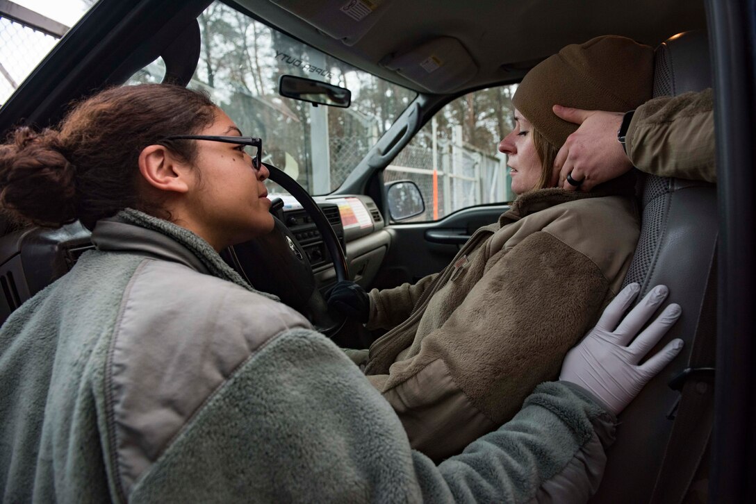 U.S. Air Force Staff Sgt. Daniela Kittrell, left, 86th Medical Group emergency response technician, checks a simulated car crash victim for injuries while another Airman steadies her head during Exercise Operation Varsity 19-04 at Ramstein Air Base, Germany, Dec. 12, 2019. According to the scenario, an Airman texted while driving and ran into a perimeter fence, sustaining head, neck and back injuries. The scenario tested the 86th MDG, the 86th Security Forces Squadron and the 86th Civil Engineer Squadron on their ability to respond to a major accident.
