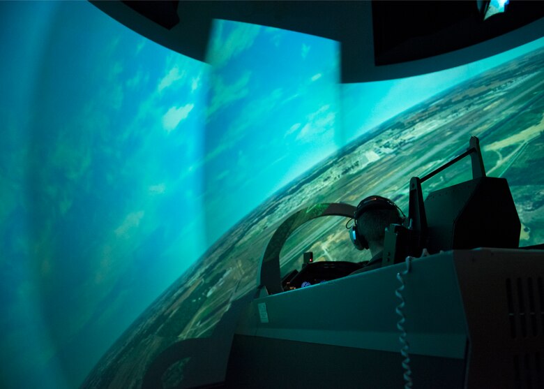 A Euro-NATO Joint Jet Pilot Training Program student pilot, simulates flying a T-6 Texan II in a Operational Flight Training simulator at Sheppard Air Force Base, Texas, Dec. 10, 2019. The OFT can be used for multiple simulations as it has both the flight-deck simulator and a 360 field of view. It is also made in a way that tricks the users brain to make them feel as if they are actually turning, going up, etc.. (U.S. Air Force photo by Senior Airman Pedro Tenorio)