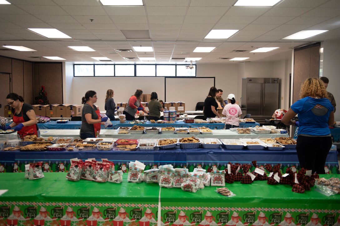 A photo of volunteers of the Moody Air Force Base Airmen Cookie Drive packing cookies.