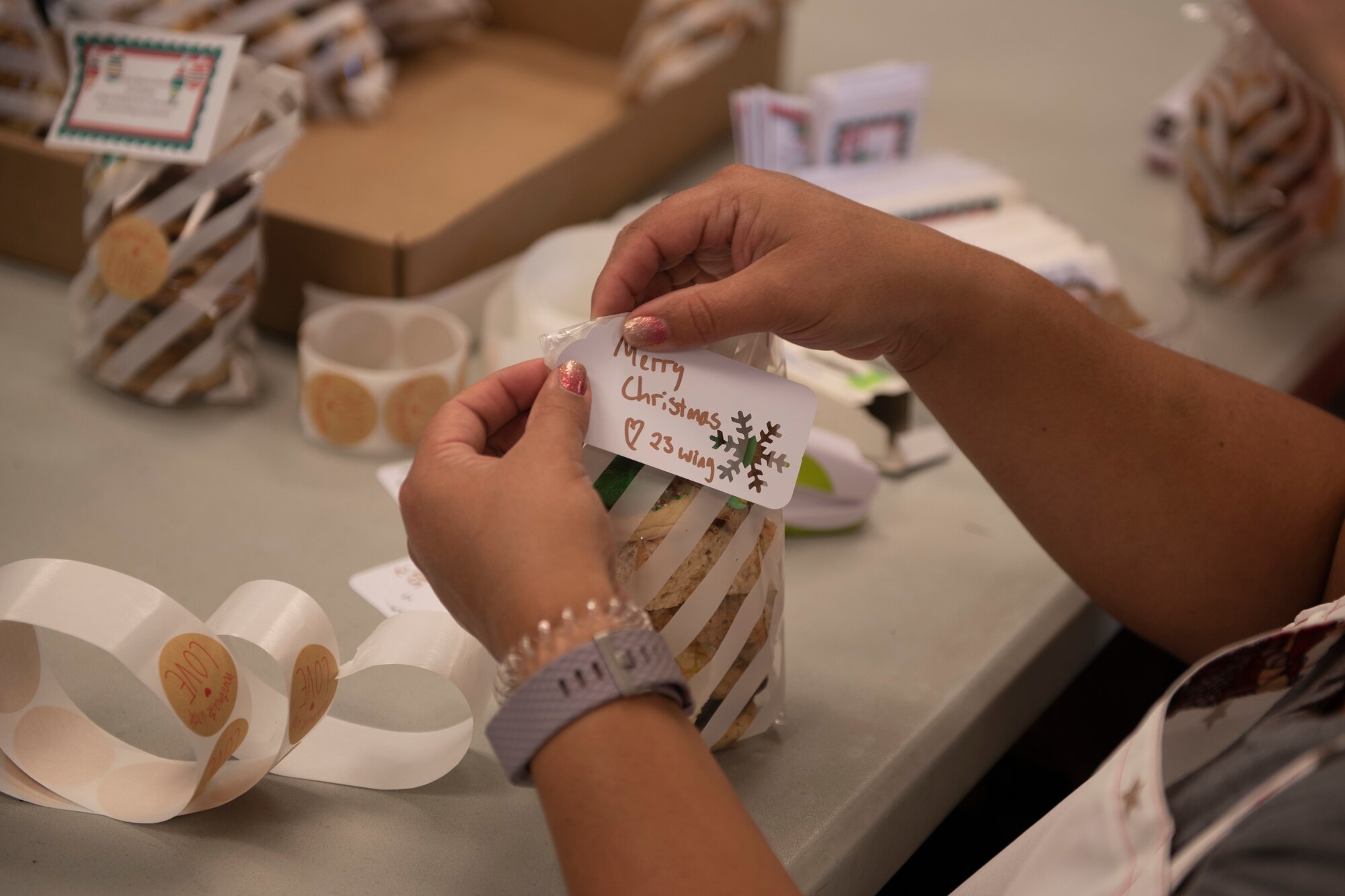 A photo of a Moody Air Force Base Airmen Cookie Drive volunteer putting the final touch on a bag of cookies.