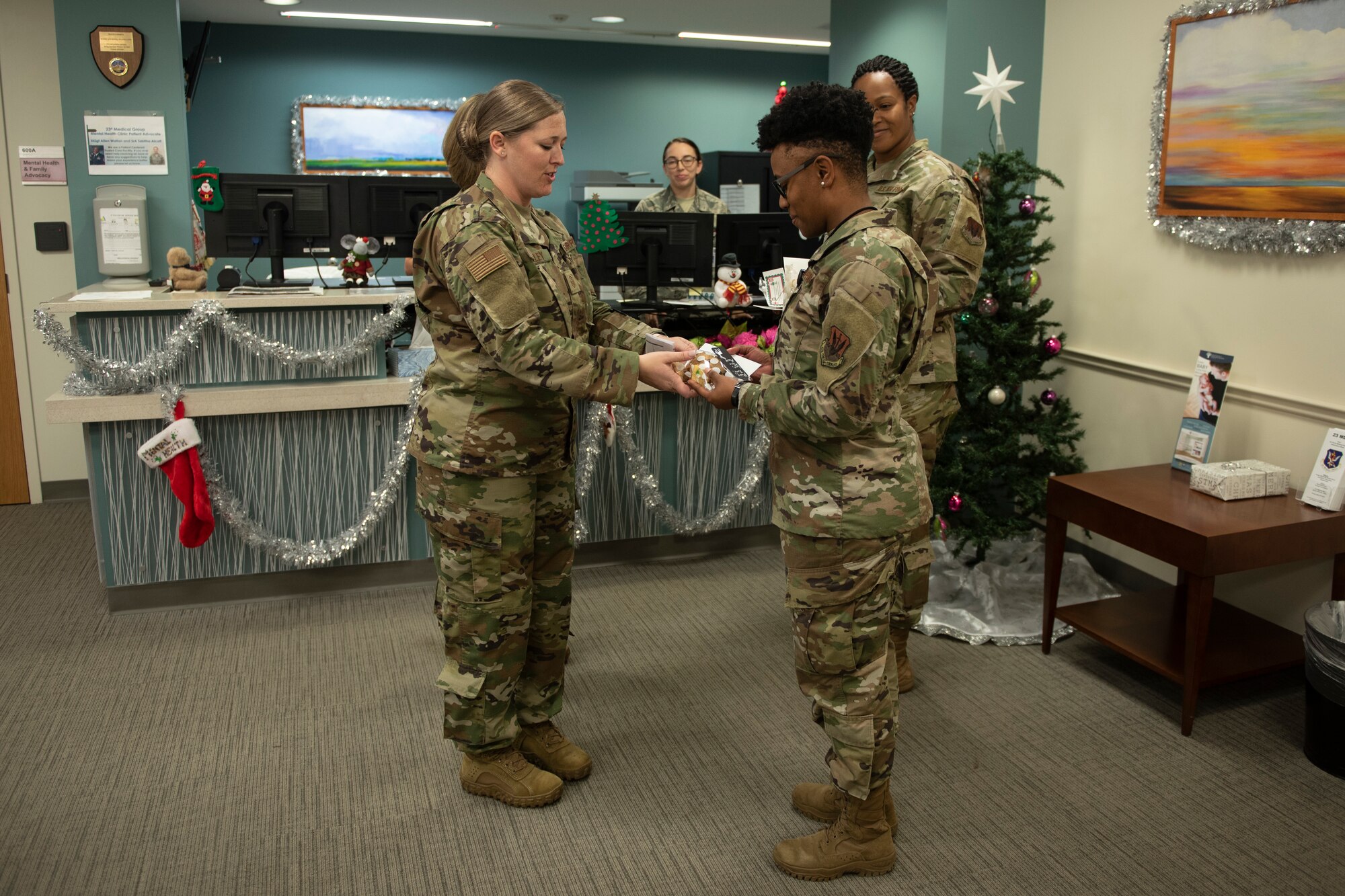A photo of an Airman delivering cookies to another Airman.