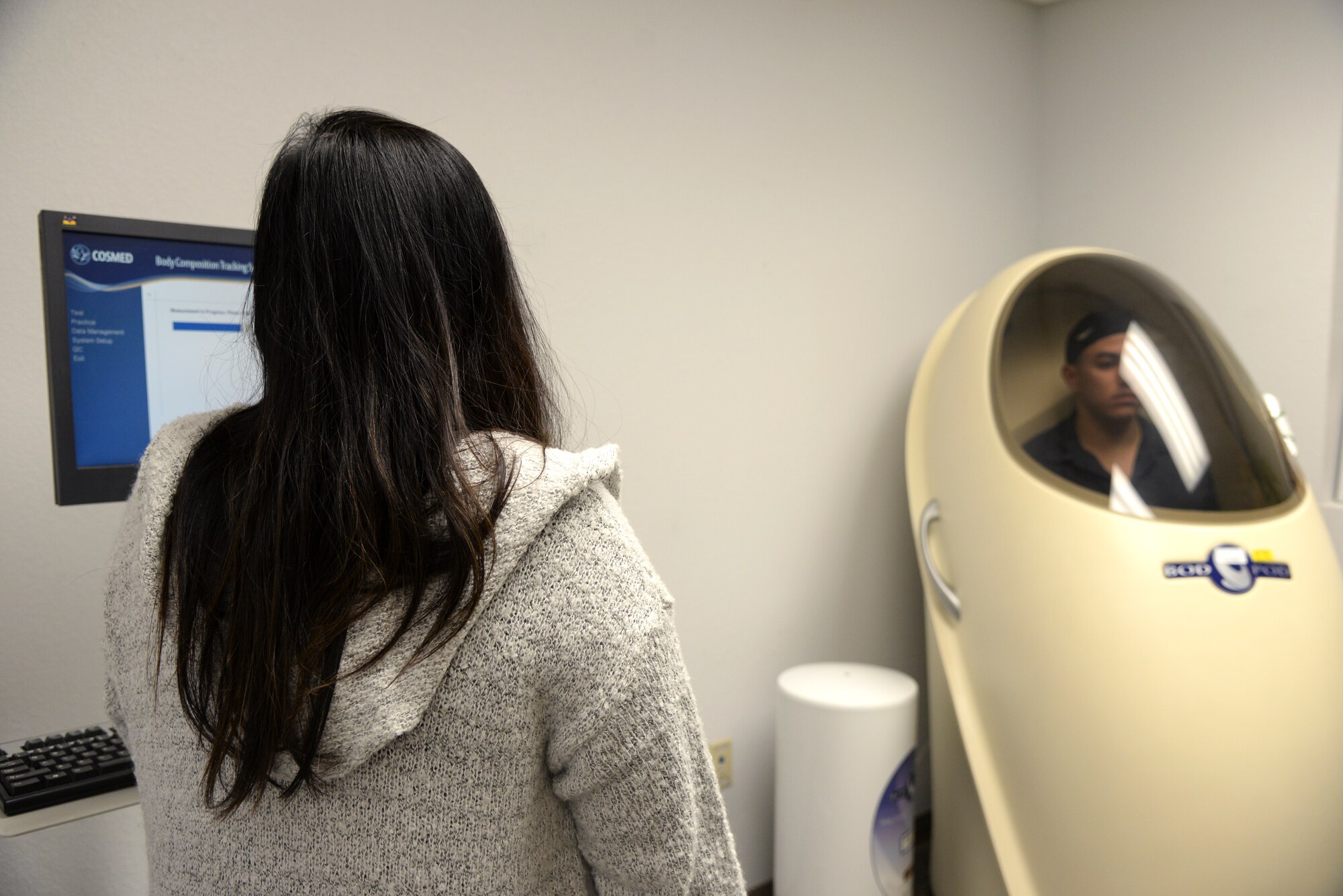 Photo of a health promotion coordinator testing someone in a body composition pod