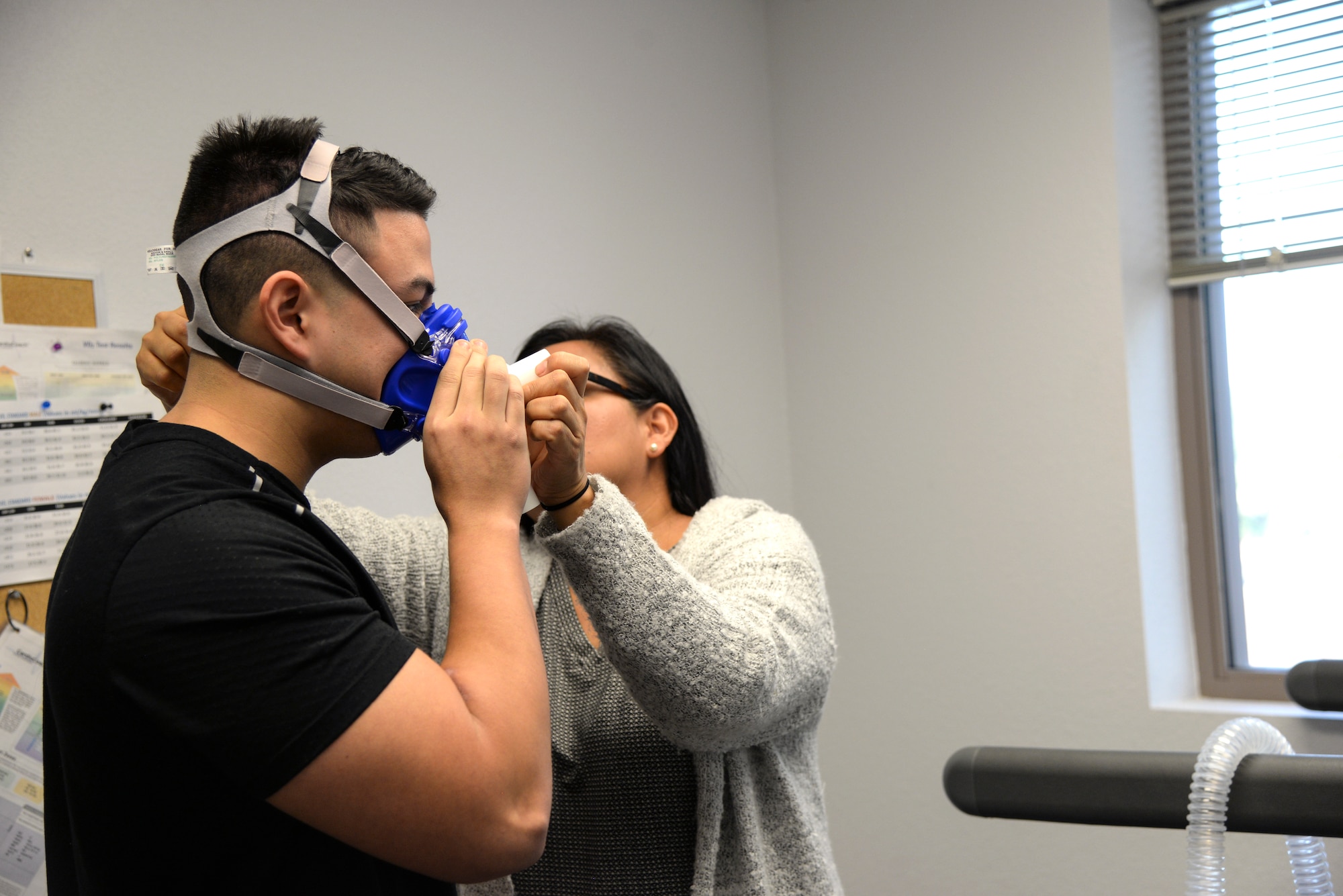 Photo of a human promotion coordinator adjust VO2 test mask on a client