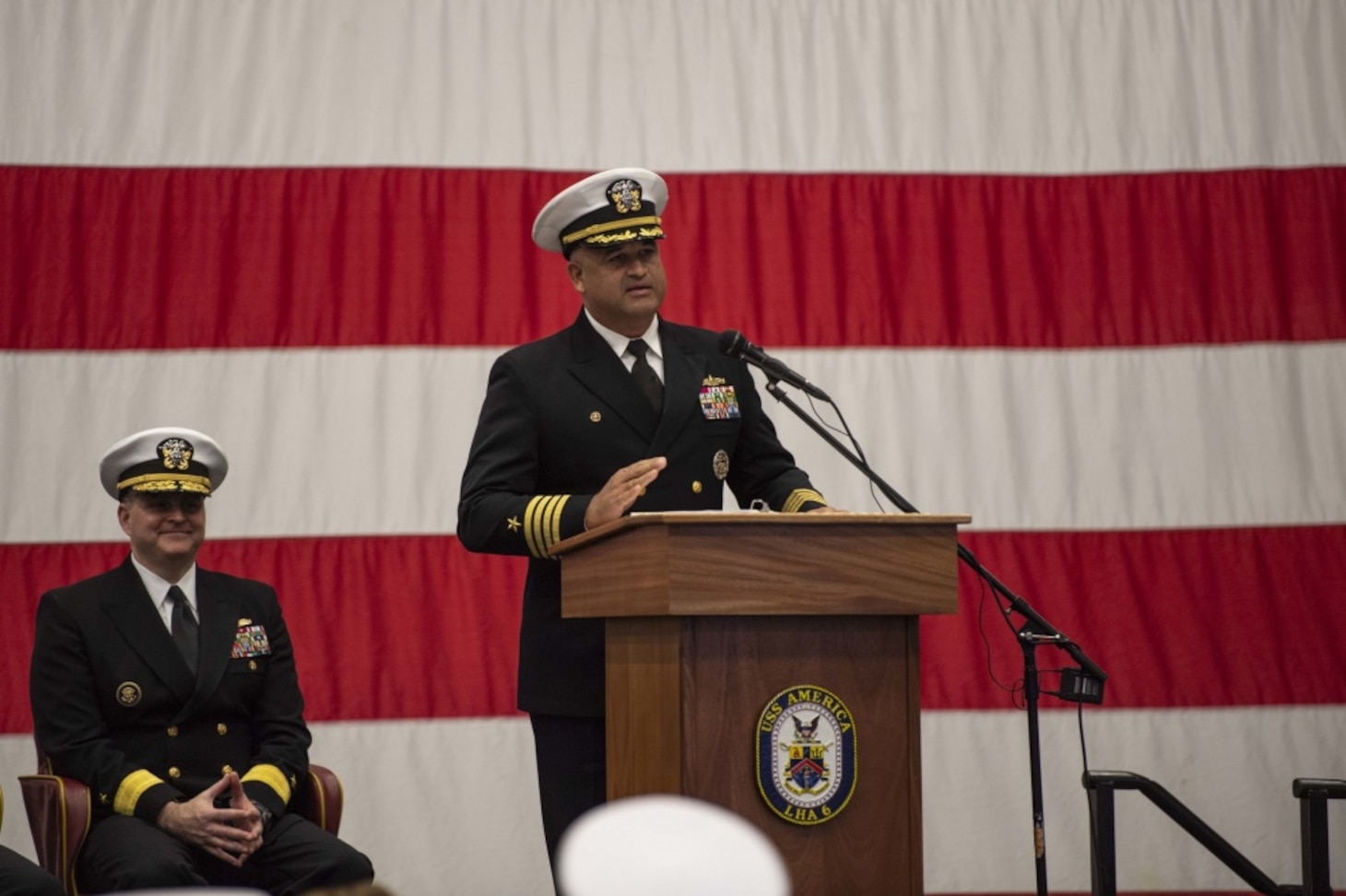 SASEBO, Japan (Dec. 11, 2019) Capt. Richard Lebron, commodore of Amphibious Squadron (PHIBRON) 11, speaks during a change of command ceremony in the hangar bay of amphibious assault ship USS America (LHA 6). Lebron relieved Capt. Jim McGovern as commodore of the only forward-deployed amphibious squadron in the U.S. Navy. America, part of Commander, PHIBRON 11 and Expeditionary Strike Group (ESG) 7, is operating in the Indo-Pacific region to enhance interoperability with partners and serve as a ready-response force for any type of contingency.
