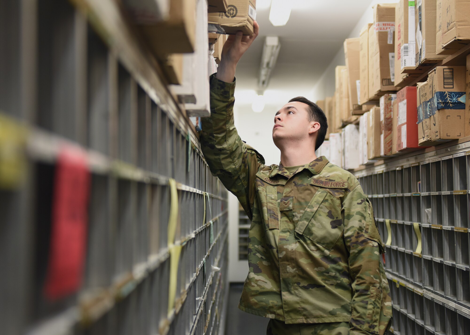 Senior Airman Tristan Greco, 51st Force Support Squadron postal clerk, searches for a customer’s package at the post office on Osan Air Base, Republic of Korea, Dec. 11, 2019. The base post office receives one to two full mail trucks on an average day. (U.S. Air Force photo by Senior Airman Denise Jenson)