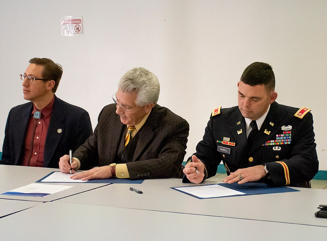 Fernando Macias (center), county manager, Dona Ana, and Lt. Col. Dale Caswell, commander, U.S. Army Corps of Engineers, Albuquerque District sign the Section 205 Small Flood Risk Management Cost Sharing Agreement during a signing ceremony at the Hatch Community Center, Hatch, New Mexico, Dec. 10, 2019. The purpose of signing the cost sharing agreement is to establish terms of funding, construction, and operation, maintenance, repair, replacement and rehabilitation of the project. USACE-Albuquerque District expects to begin the design phase of this project this coming spring.
