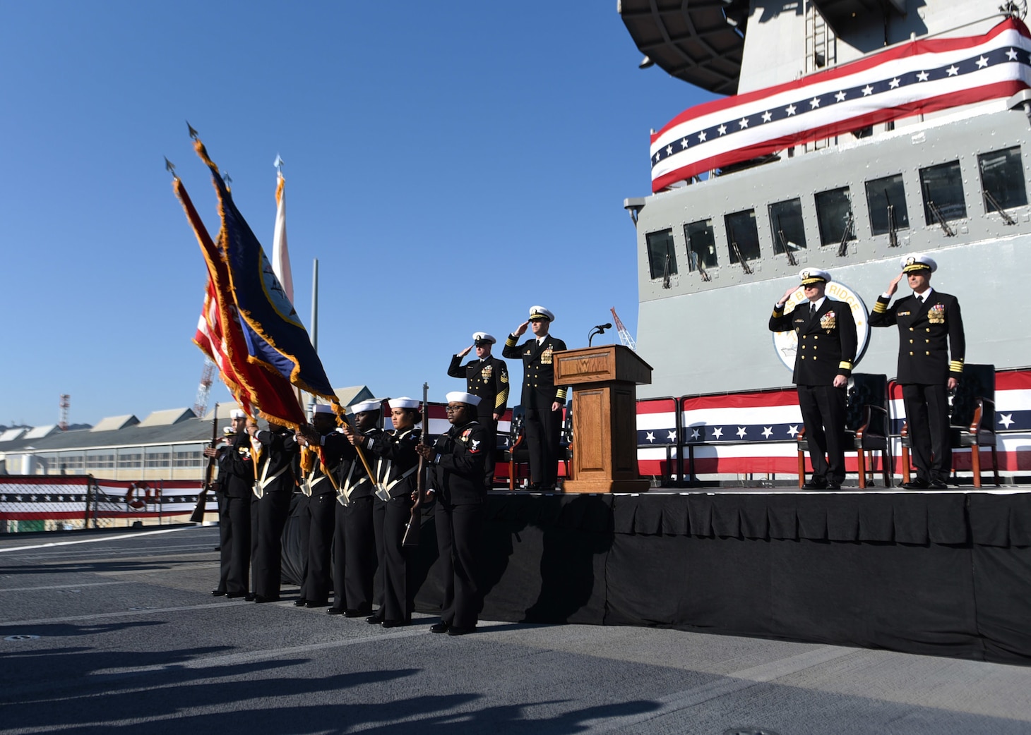 Japan (Dec. 12, 2019) The official party renders a hand salute as colors are paraded during the U.S. 7th Fleet flagship USS Blue Ridge (LCC 19) change of command ceremony. Capt. Craig C. Sicola, of Dallas, relieved Capt. Eric J. Anduze, from Manati, Puerto Rico, as the ship's commanding officer. Blue Ridge, a part of Expeditionary Strike Group 7, is the oldest operational ship in the Navy and, as 7th Fleet command ship, actively works to foster relationships with allies and partners in support of security and stability within the Indo-Pacific Region.