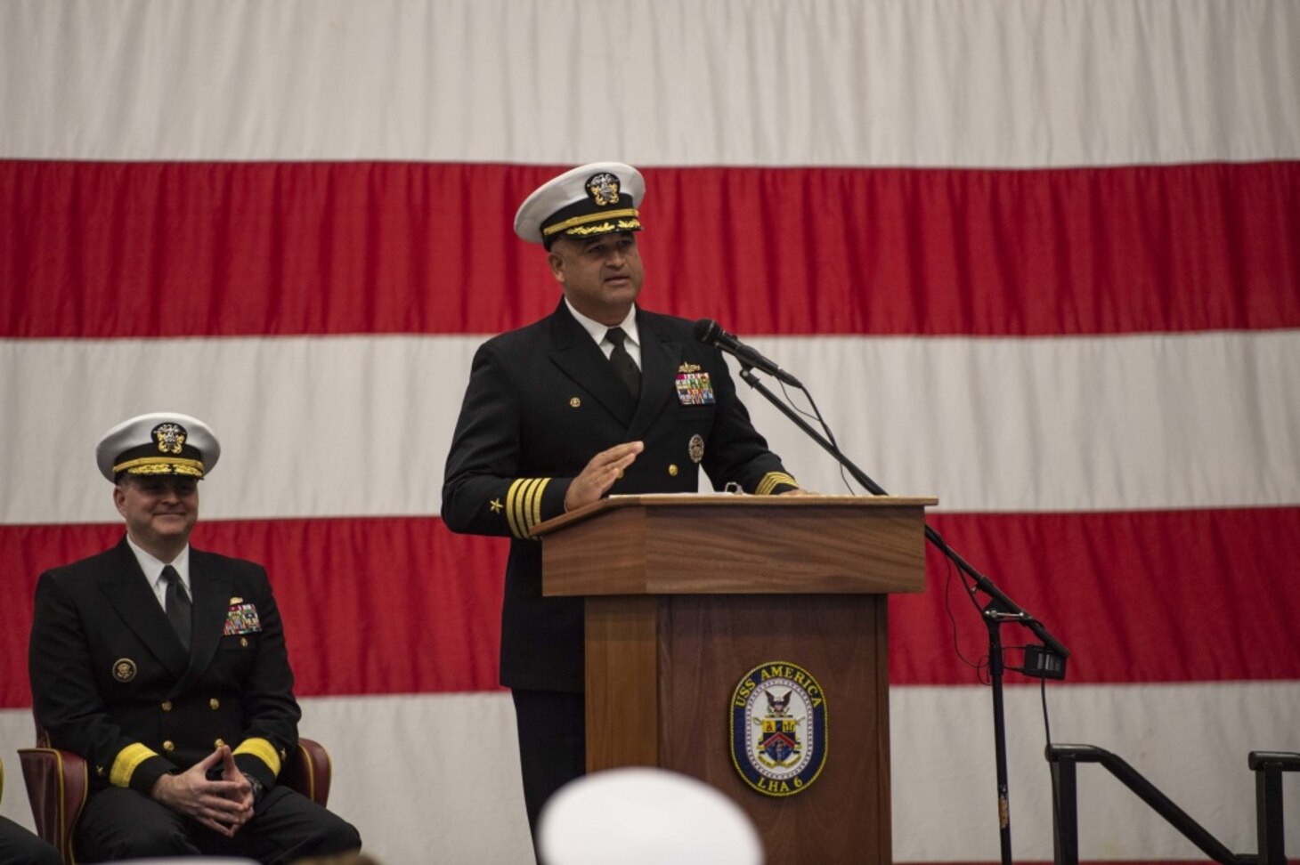 SASEBO, Japan (Dec. 11, 2019) Capt. Richard Lebron, commodore of Amphibious Squadron (PHIBRON) 11, speaks during a change of command ceremony in the hangar bay of amphibious assault ship USS America (LHA 6). Lebron relieved Capt. Jim McGovern as commodore of the only forward-deployed amphibious squadron in the U.S. Navy. America, part of Commander, PHIBRON 11 and Expeditionary Strike Group (ESG) 7, is operating in the Indo-Pacific region to enhance interoperability with partners and serve as a ready-response force for any type of contingency.
